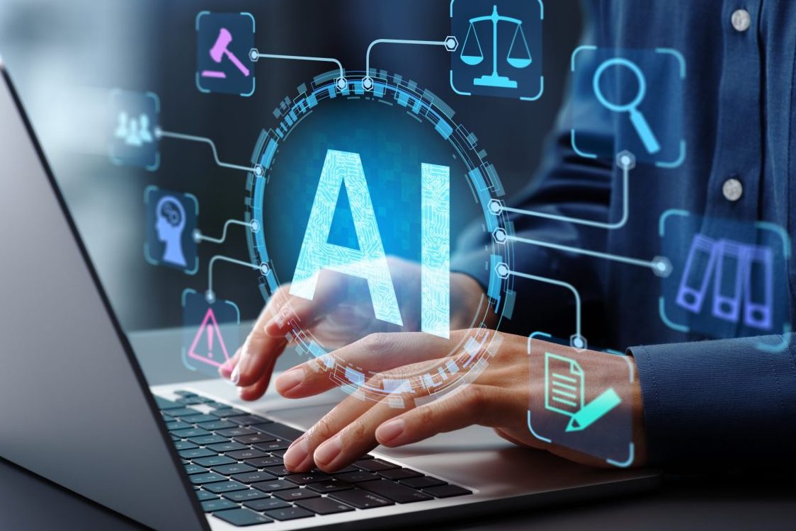 Businessman typing on laptop computer keyboard at desk in office.